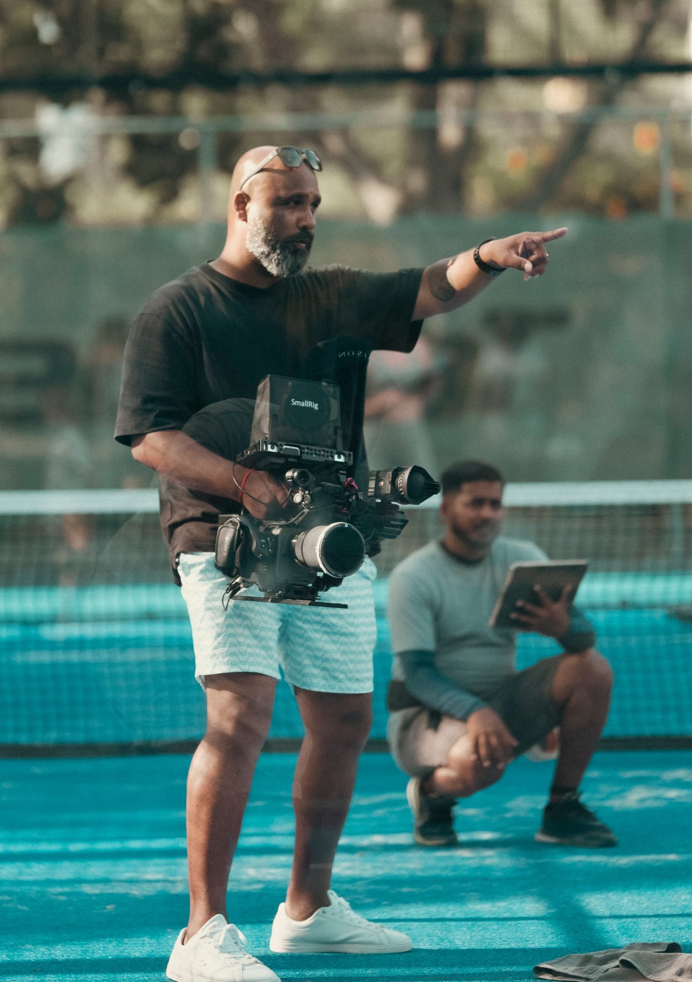 Arvind Mattadeen on set with a camera rig, pointing out a shot